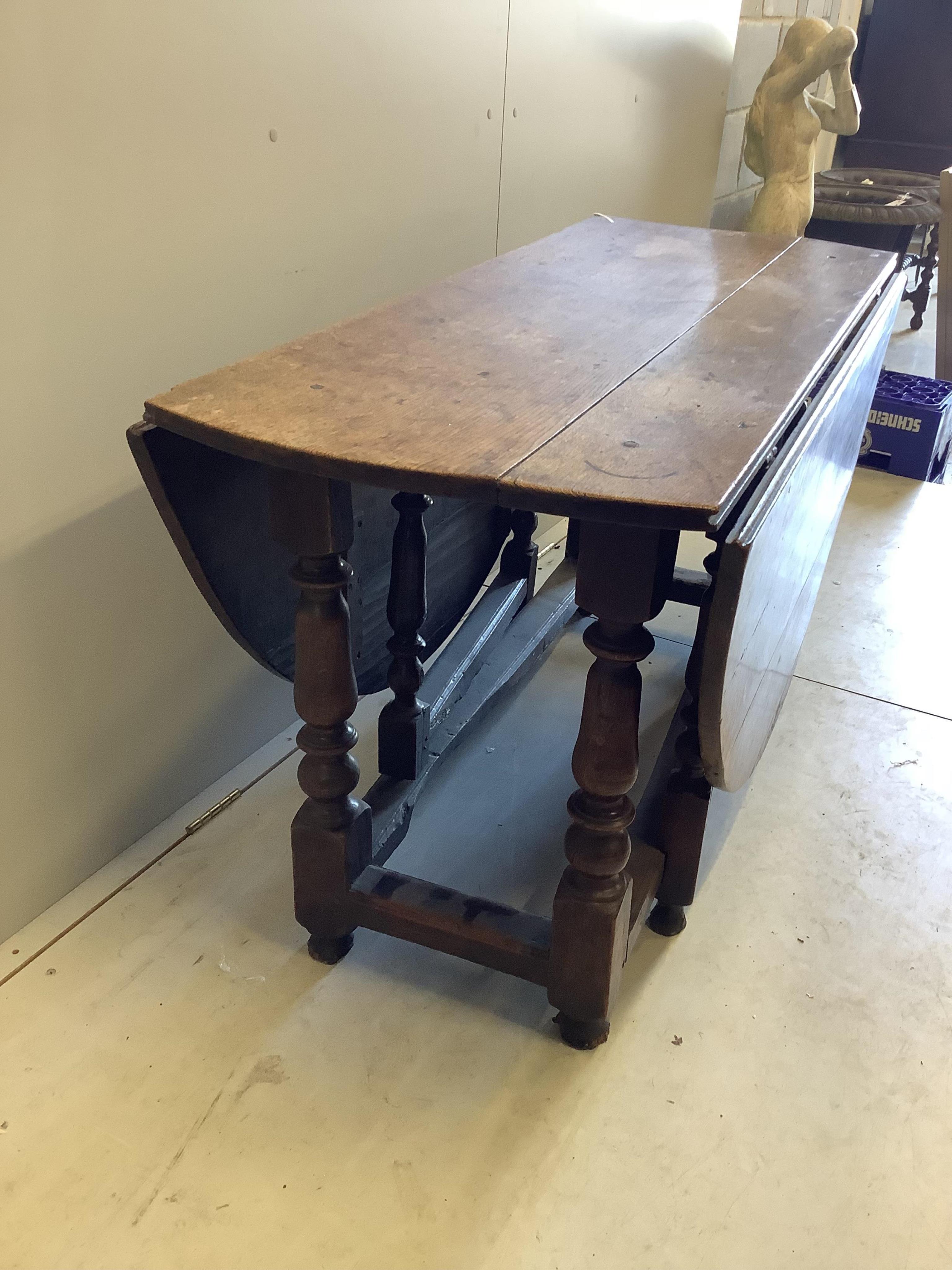 An 18th century oak gateleg table, width 135cm, depth 55cm, height 73cm. Condition - poor to fair